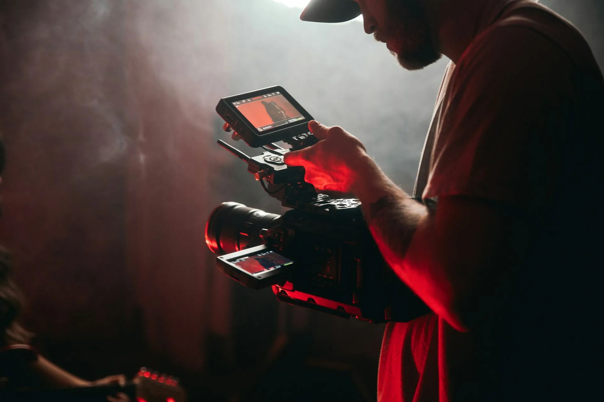 Operador de cámara sosteniendo equipo de vídeo profesional en sesión de grabación