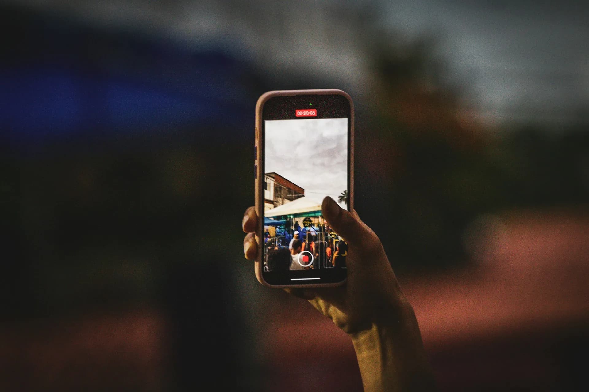 Person recording vertical video with a phone in hand