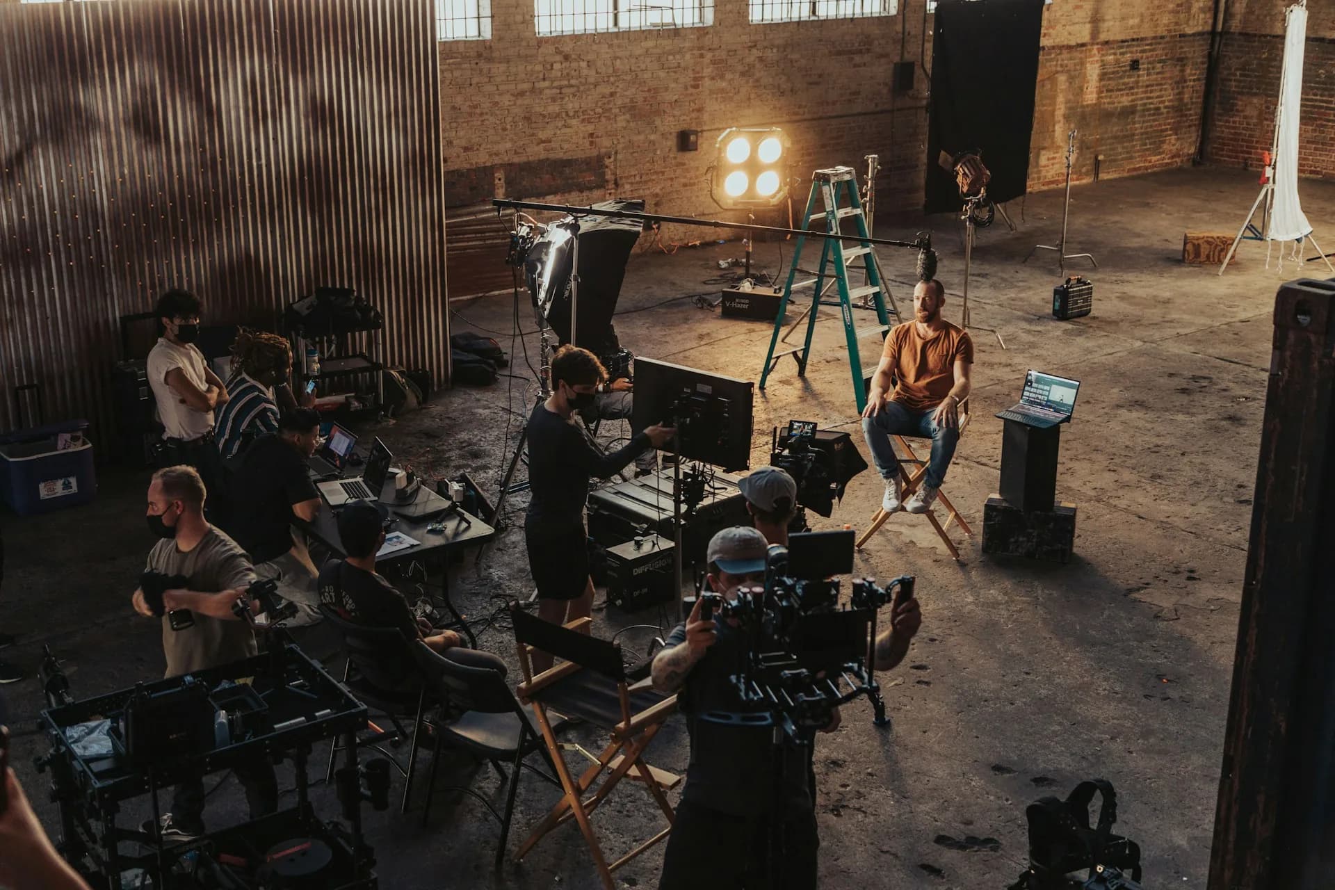 Equipo de producción reunido alrededor de una cámara durante el rodaje de un spot